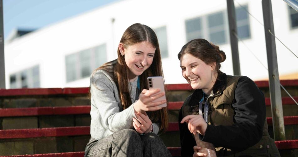 Two female students looking at a phone