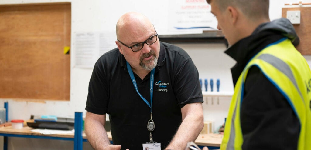 Plumbing staff member helping a student