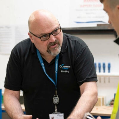 Plumbing staff member helping a student