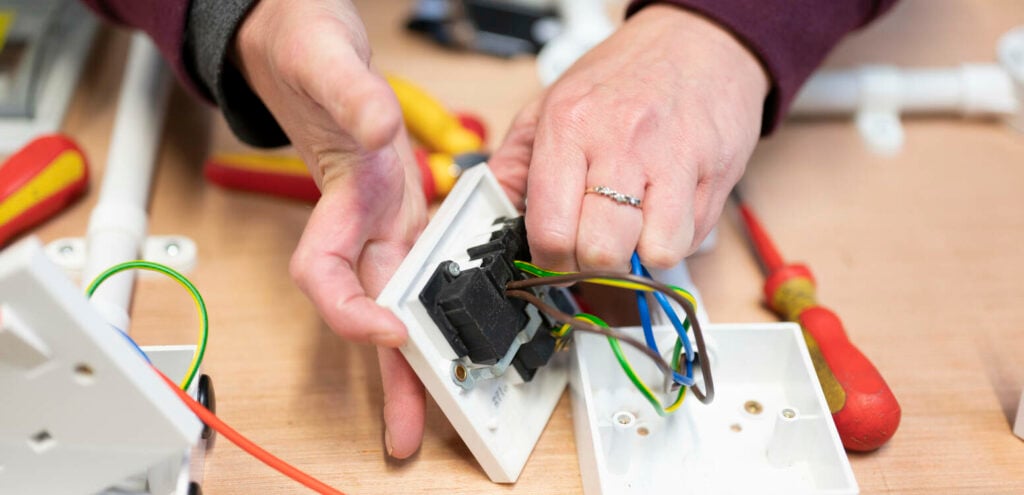 Electrical student working on a plug socket wiring