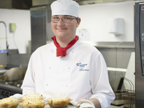 Catering student taking shepherds pie out of the oven