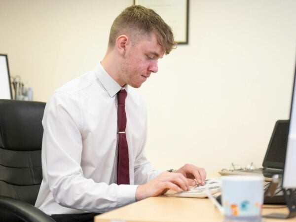 Business apprentice working at his desk.