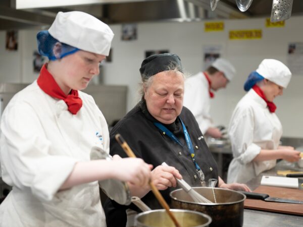 Catering staff member helping student