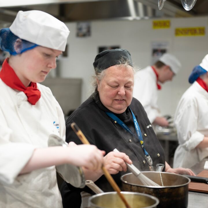 Catering staff member helping student
