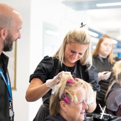 Hairdressing student and tutor working on a client