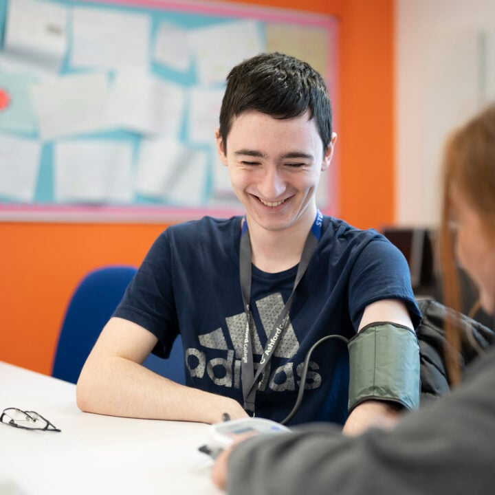 Health and social care student taking a blood pressure reading