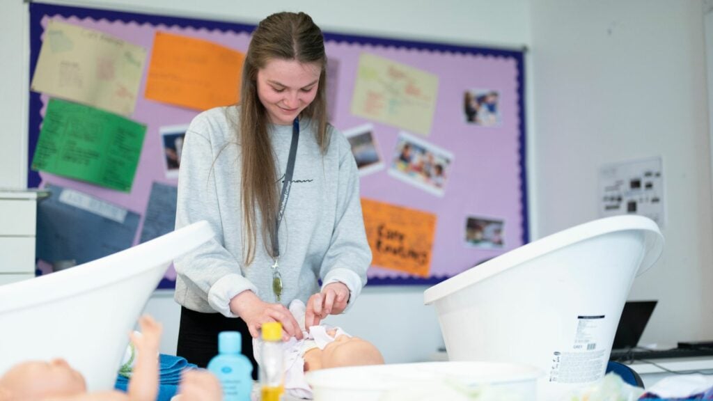 Early Years Student In Classroom working with baby