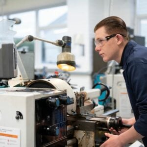 Engineering student using lathe machine