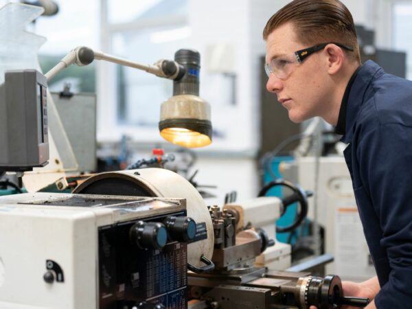 Engineering student using lathe machine