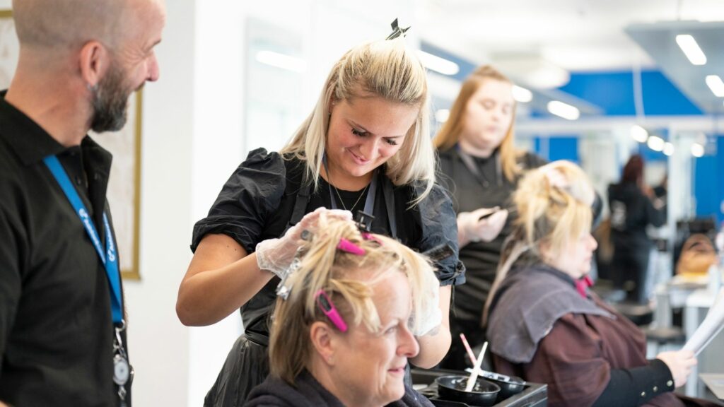 Hairdressing student and tutor working on a client