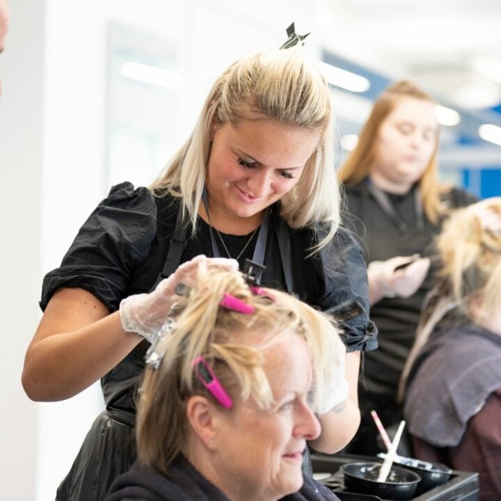 Hairdressing student and tutor working on a client