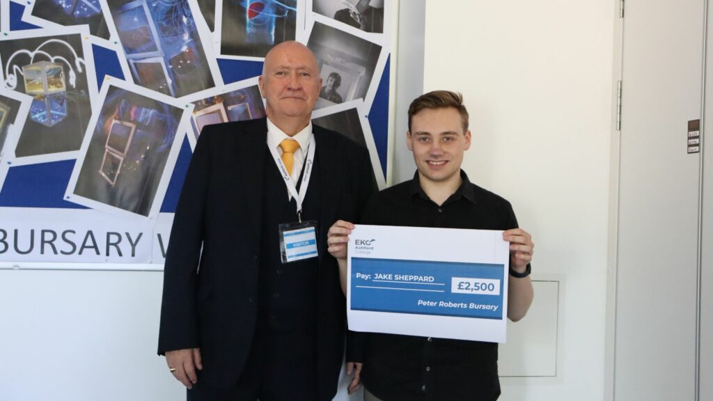 Peter Roberts Bursary Award winner, Jake, holding a cheque presented by Peter McCann, Chair for Quality and Safeguarding at the Skills Network