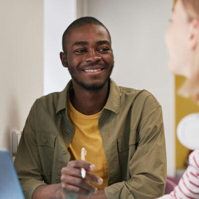 A couple of people chatting in front of a laptop