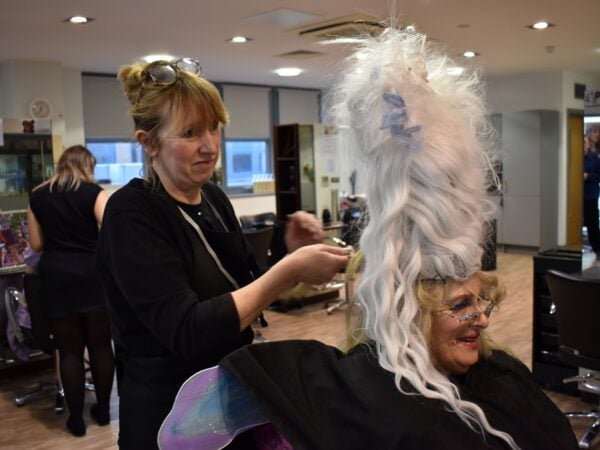 Woman working on unique hair style for skills competition