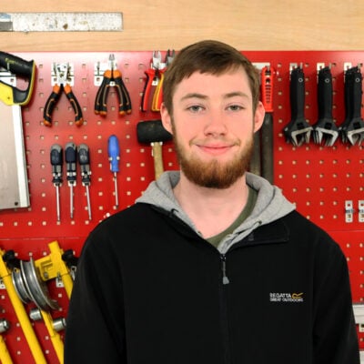 Man standing in front of a wall filled with tools