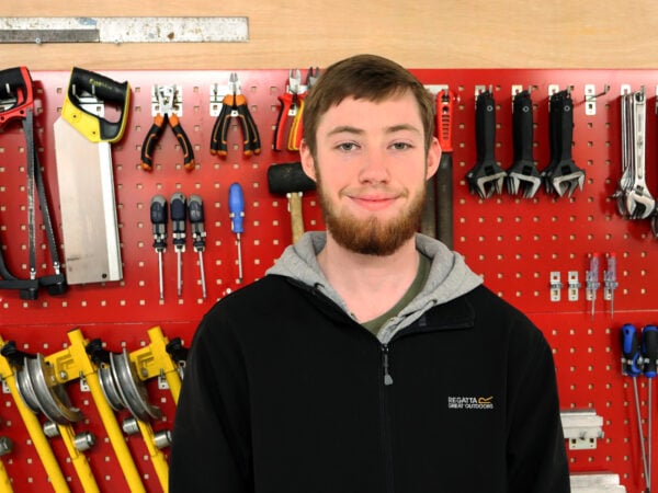 Man standing in front of a wall filled with tools