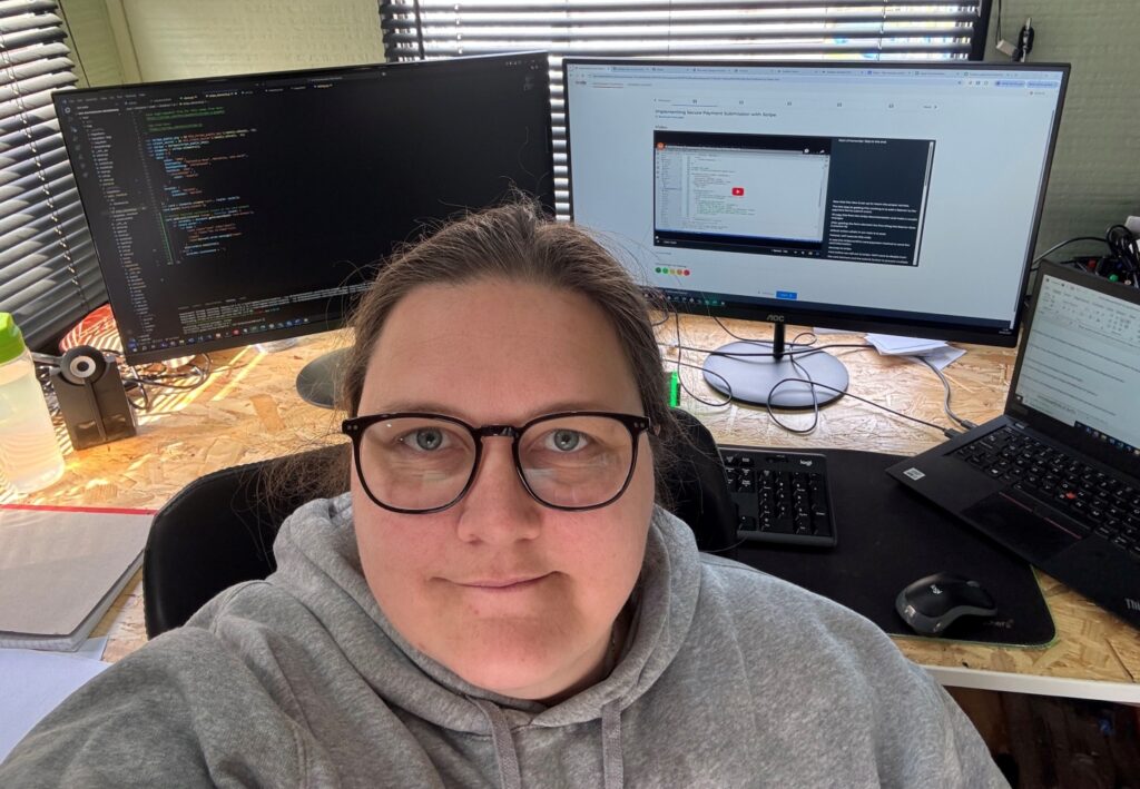 headshot of a woman in front of three computer screens