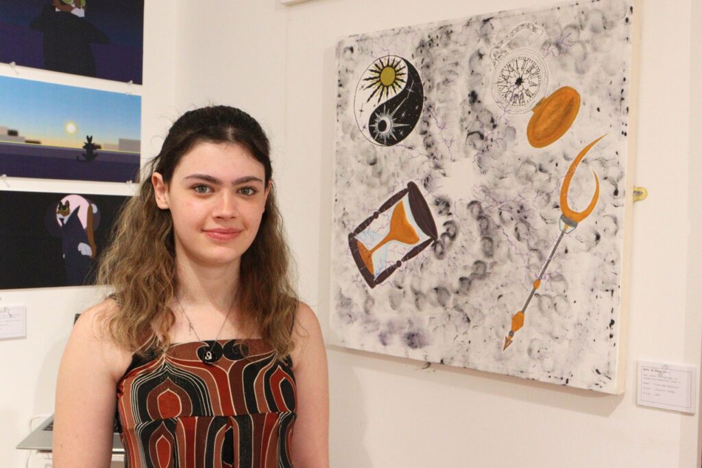 Young student standing in front of her painting