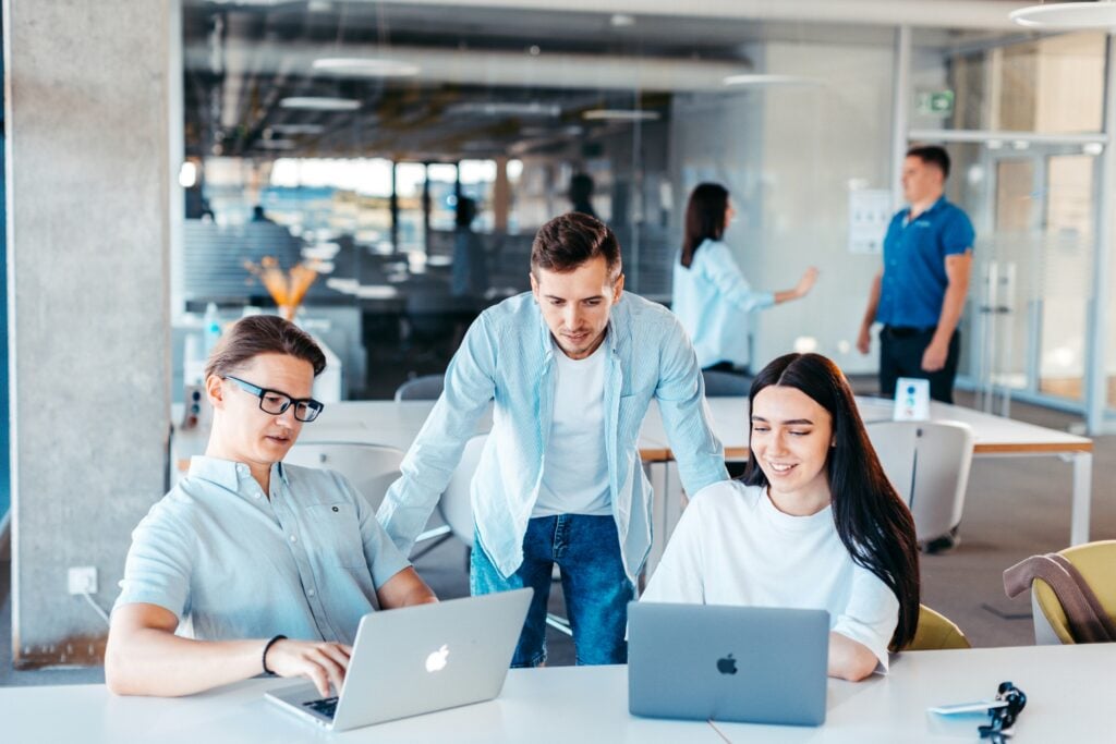 group of students in a meeting, looking at laptops