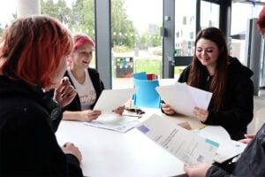 Happy students sat at a table looking at results