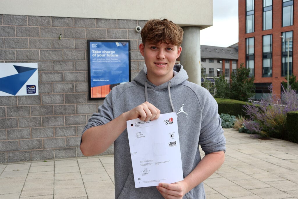 Young man holding a certificate smiling