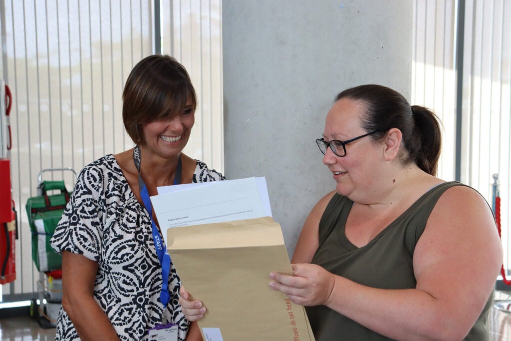 2 woman looking a exam certificate - both look very proud