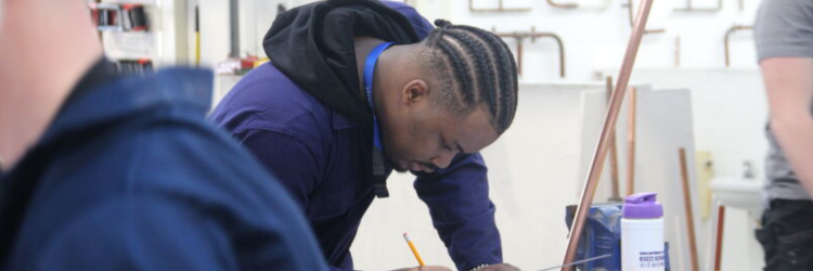 man using pencil to measure pipes