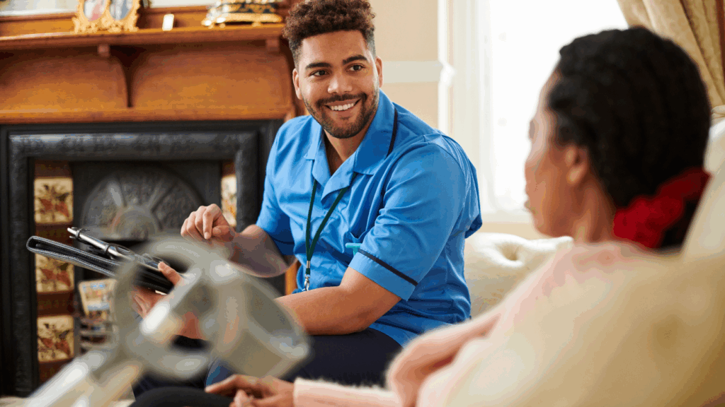 A care worker sat on a sofa with his client
