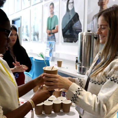 student giving hot chocolate to another student