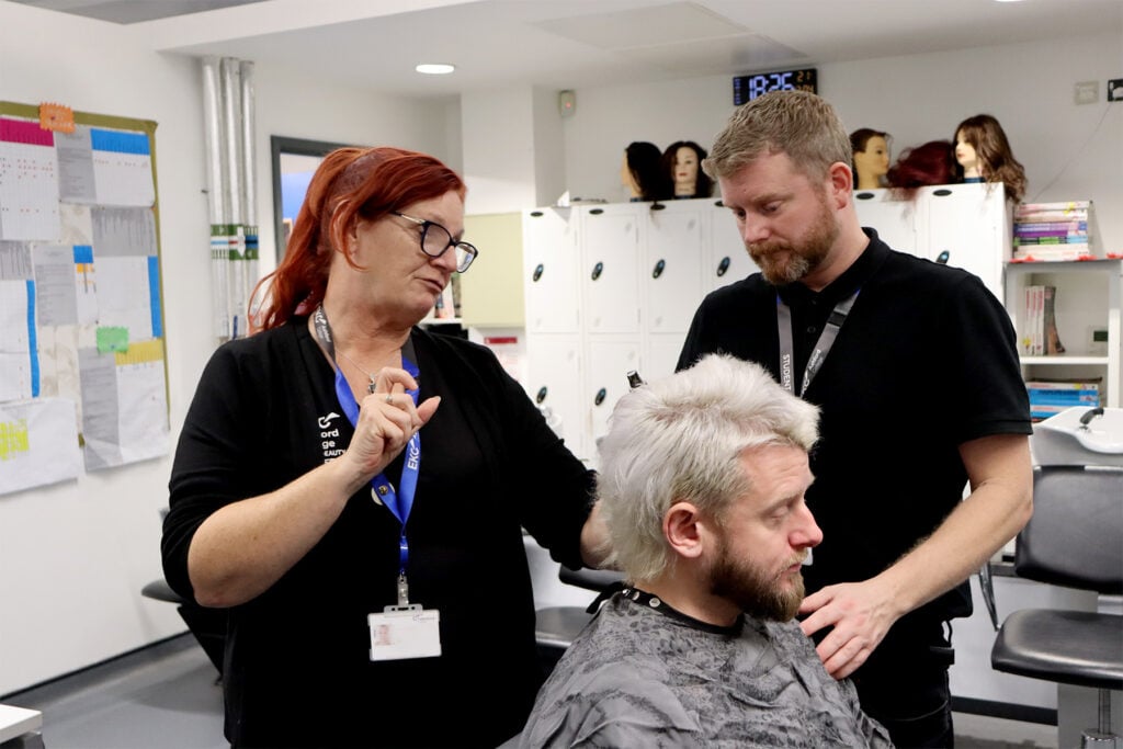 Tutor and students working with a barbering client