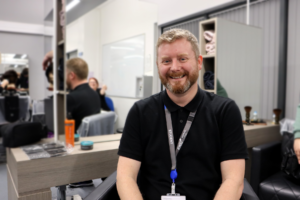 Male sat in salon chair smiling at the camera