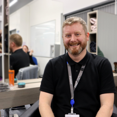 Male sat in salon chair smiling at the camera