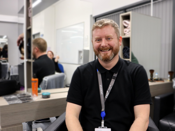 Male sat in salon chair smiling at the camera