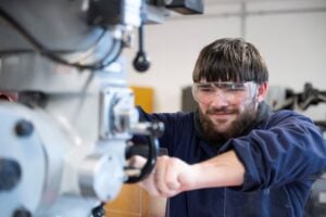 Male student using CNC machine