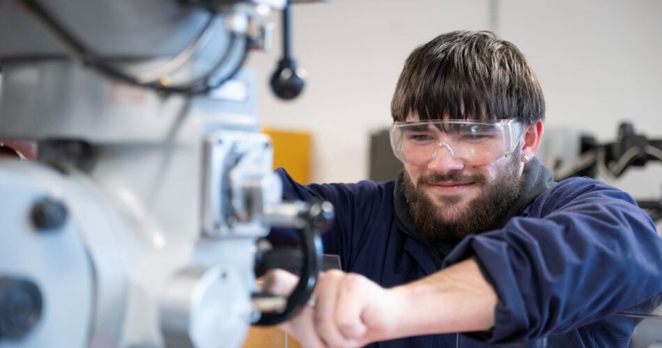 Male student using CNC machine