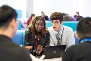 Access to HE students looking at a laptop together in the E-Hub.