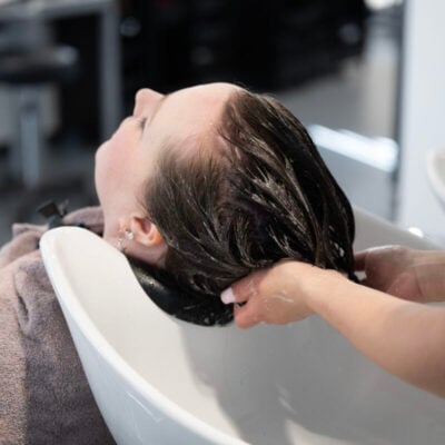 woman getting hair washed in a sink