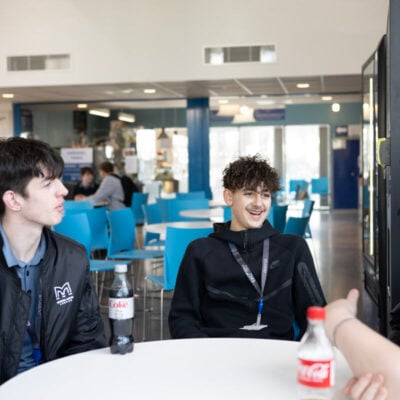 students sitting around a table in the refectory area