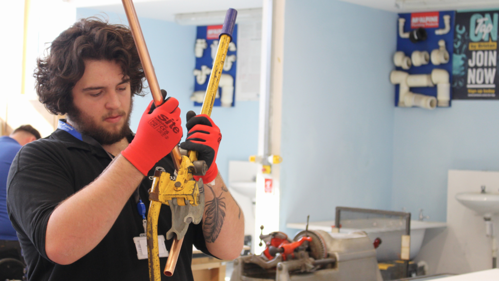Student being pipes at a workbench.