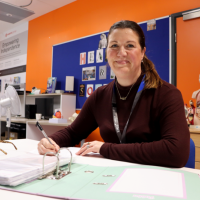 Lady in a classroom working using a folder