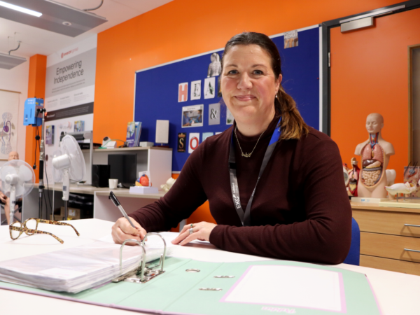 Lady in a classroom working using a folder