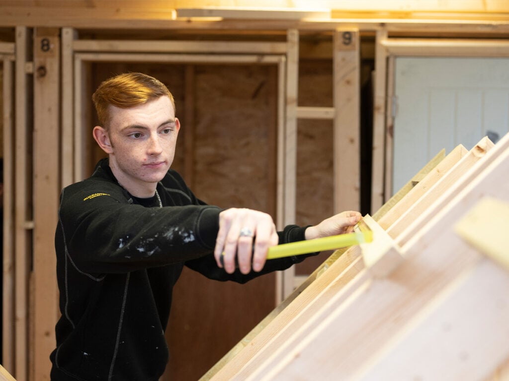 student sanding down woodwork
