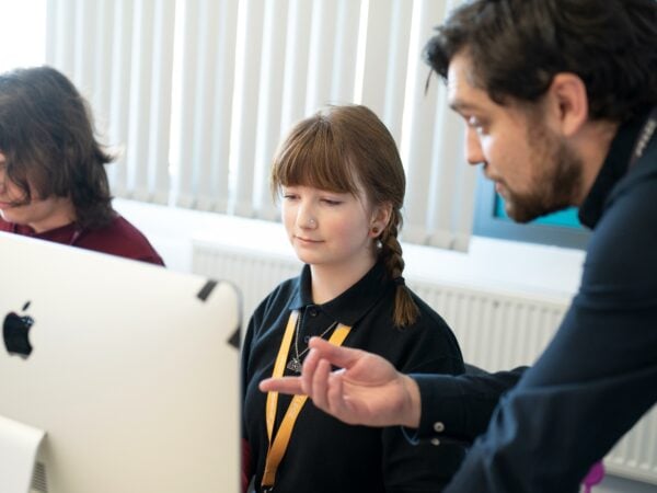 Student with tutor, working on a MAC