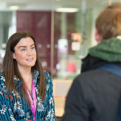 Staff member talking to student at reception