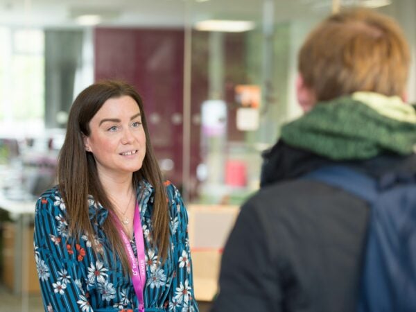 Staff member talking to student at reception