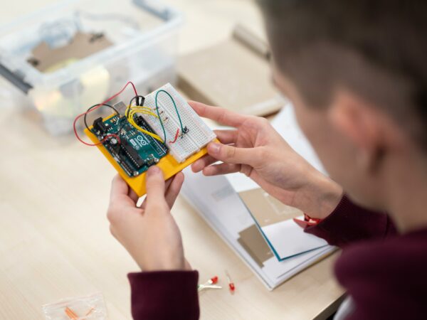 Computing student looking at robotics master board