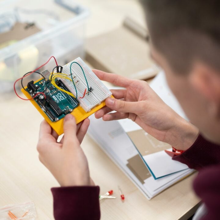 Computing student looking at robotics master board