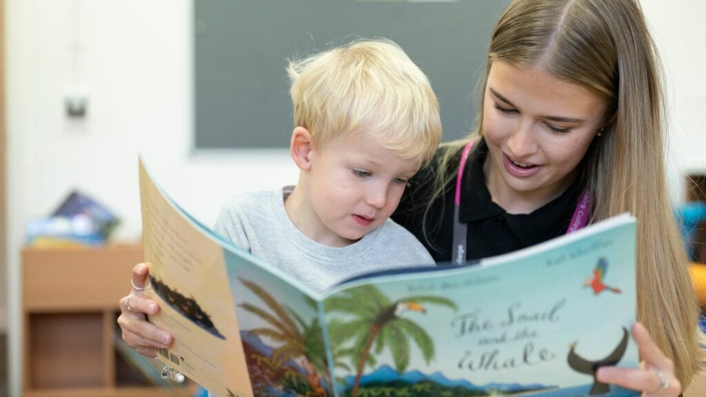 Student reading to child