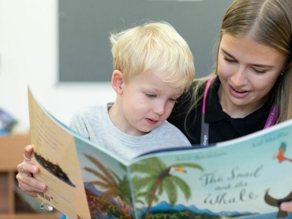 Student reading to child