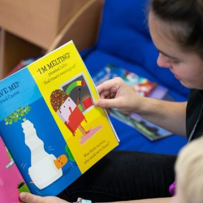 Student reading to child in nursery
